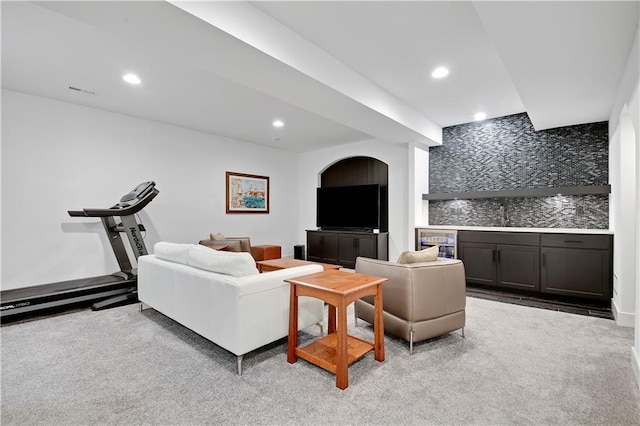 living room featuring bar, light carpet, and recessed lighting