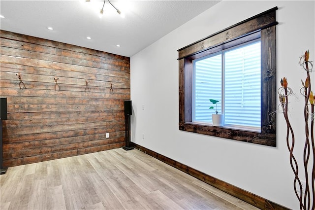 spare room with wood finished floors, recessed lighting, baseboards, and wooden walls