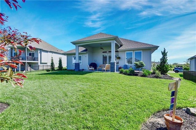 view of front of property with ceiling fan, a shingled roof, and a patio