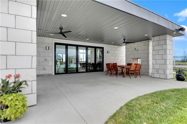view of patio featuring outdoor dining area, fence, and a ceiling fan