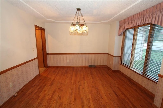 6726 Mill Creek Rd, Shawnee, KS 66217 - spare room featuring wallpapered walls, wood finished floors, a wainscoted wall, a chandelier, and a textured ceiling