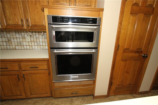 6726 Mill Creek Rd, Shawnee, KS 66217 - kitchen featuring double oven, brown cabinets, decorative backsplash, and light countertops