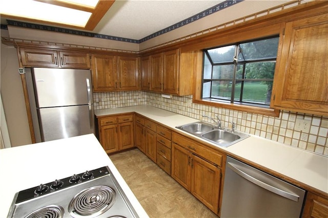 6726 Mill Creek Rd, Shawnee, KS 66217 - kitchen with appliances with stainless steel finishes, a sink, brown cabinets, and light countertops