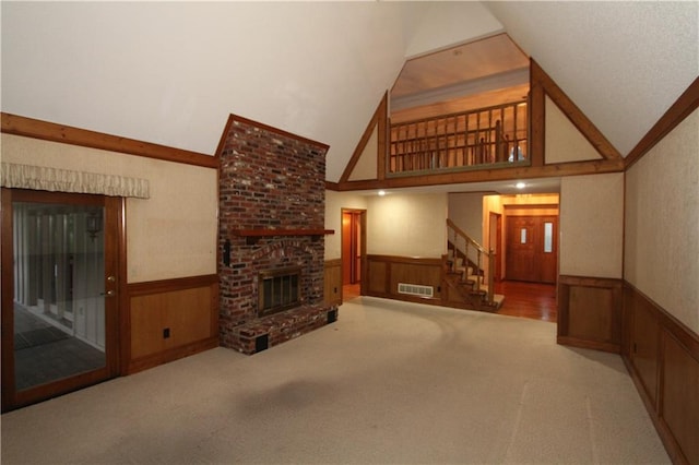 6726 Mill Creek Rd, Shawnee, KS 66217 - unfurnished living room with a wainscoted wall, stairs, high vaulted ceiling, a fireplace, and carpet floors