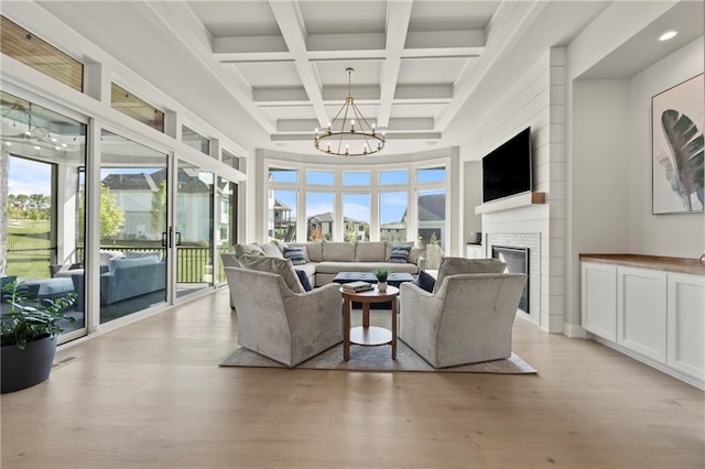 11201 W 169th St, Overland Park, KS 66221 - living area featuring a chandelier, light wood-style flooring, beam ceiling, coffered ceiling, and a glass covered fireplace