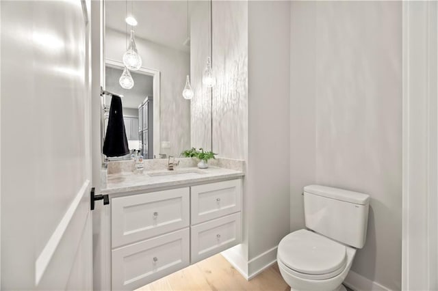 11201 W 169th St, Overland Park, KS 66221 - bathroom with vanity, toilet, baseboards, and wood finished floors