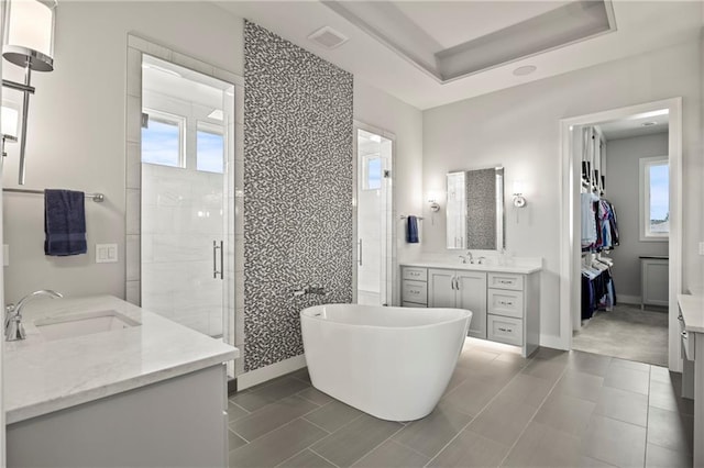 11201 W 169th St, Overland Park, KS 66221 - full bath featuring two vanities, a stall shower, a freestanding tub, and baseboards