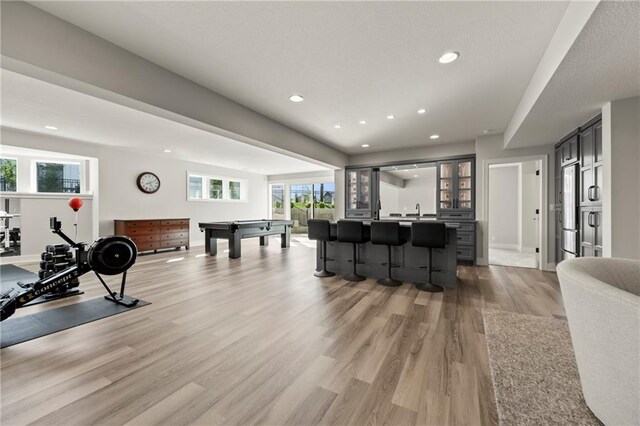 11201 W 169th St, Overland Park, KS 66221 - living room featuring light wood-style floors, billiards table, recessed lighting, bar with sink, and baseboards