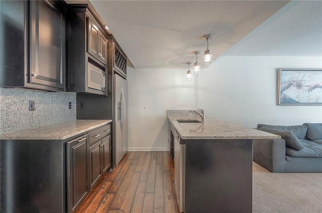3536 SW Dana Ave E, Lees Summit, MO 64082 - kitchen with a sink, open floor plan, white microwave, backsplash, and light stone countertops