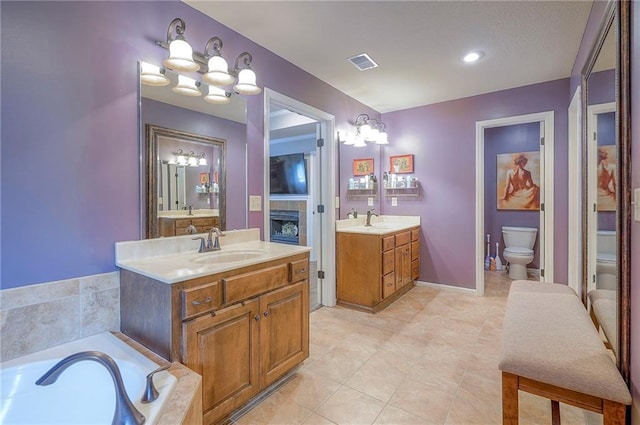 3536 SW Dana Ave E, Lees Summit, MO 64082 - full bath featuring toilet, a chandelier, two vanities, and tile patterned floors
