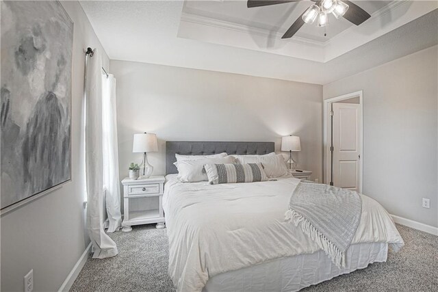 bedroom featuring baseboards, ceiling fan, carpet, and a tray ceiling