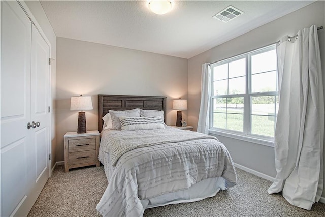bedroom featuring visible vents, baseboards, and light carpet