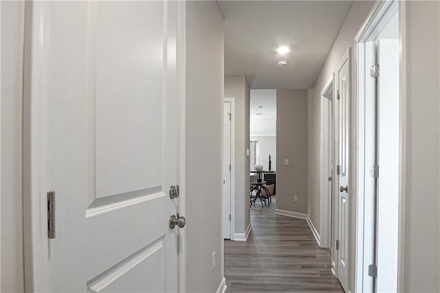 corridor featuring dark wood-style flooring, baseboards, and recessed lighting