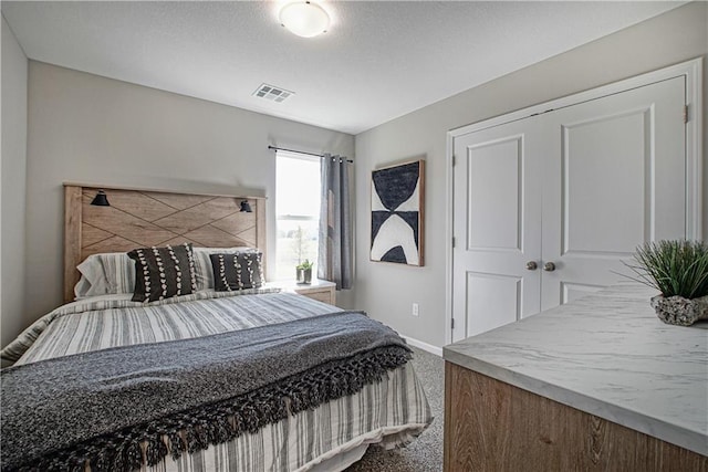 carpeted bedroom with baseboards, visible vents, and a closet