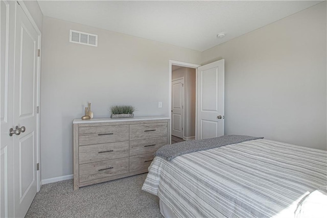 bedroom with baseboards, visible vents, and light carpet