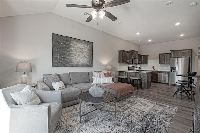 living room featuring a ceiling fan, vaulted ceiling, dark wood finished floors, and recessed lighting