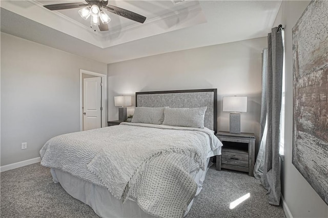 bedroom with crown molding, baseboards, ceiling fan, a tray ceiling, and carpet