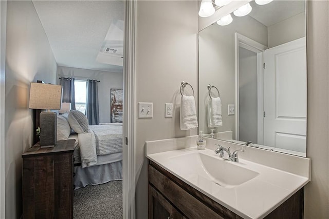 ensuite bathroom with vanity, visible vents, and connected bathroom