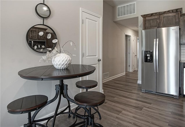 dining space with baseboards, dark wood-style flooring, and visible vents