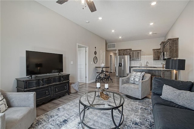 living room featuring light wood-style floors, ceiling fan, recessed lighting, and visible vents