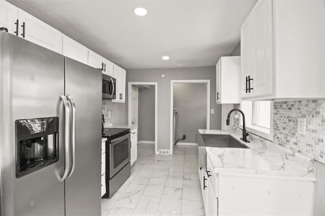 6101 Swope Pkwy, Kansas City, MO 64130 - kitchen featuring appliances with stainless steel finishes, light marble finish floors, recessed lighting, white cabinetry, and backsplash