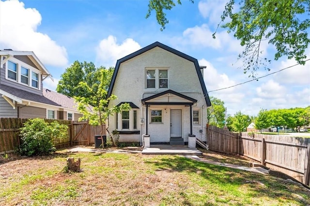 6101 Swope Pkwy, Kansas City, MO 64130 - back of property with a gambrel roof and a fenced backyard