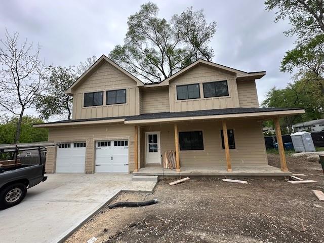 5400 W 79th St, Prairie Village, KS 66208 - view of front of house with covered porch, an attached garage, concrete driveway, and board and batten siding