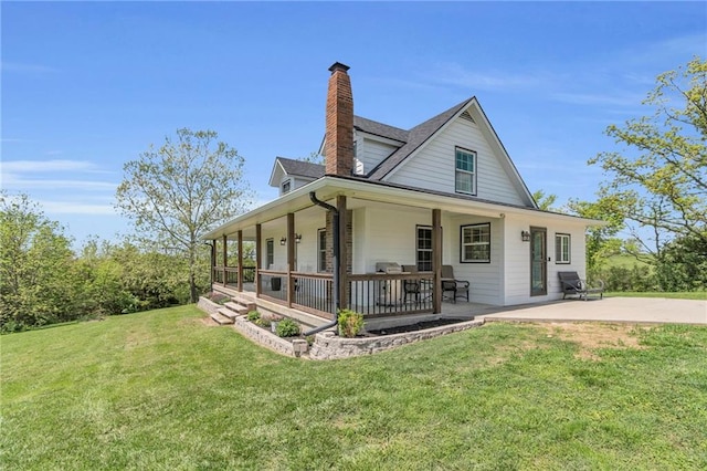 view of front facade featuring a chimney, covered porch, and a front lawn