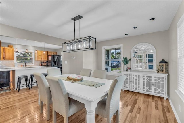 dining area featuring light wood finished floors, a wealth of natural light, and recessed lighting