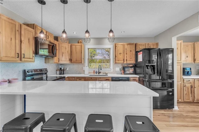 kitchen with light wood finished floors, a sink, stainless steel electric range, a textured ceiling, and black refrigerator with ice dispenser