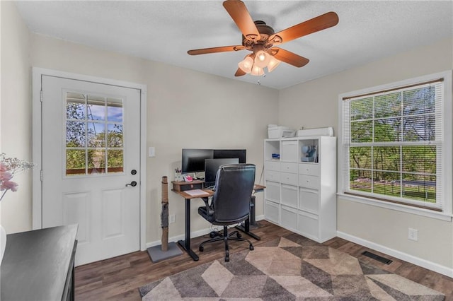 office space featuring plenty of natural light, baseboards, visible vents, and wood finished floors