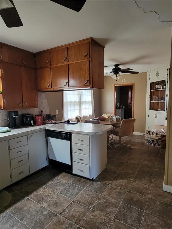 kitchen featuring light countertops, a ceiling fan, a peninsula, and dishwasher