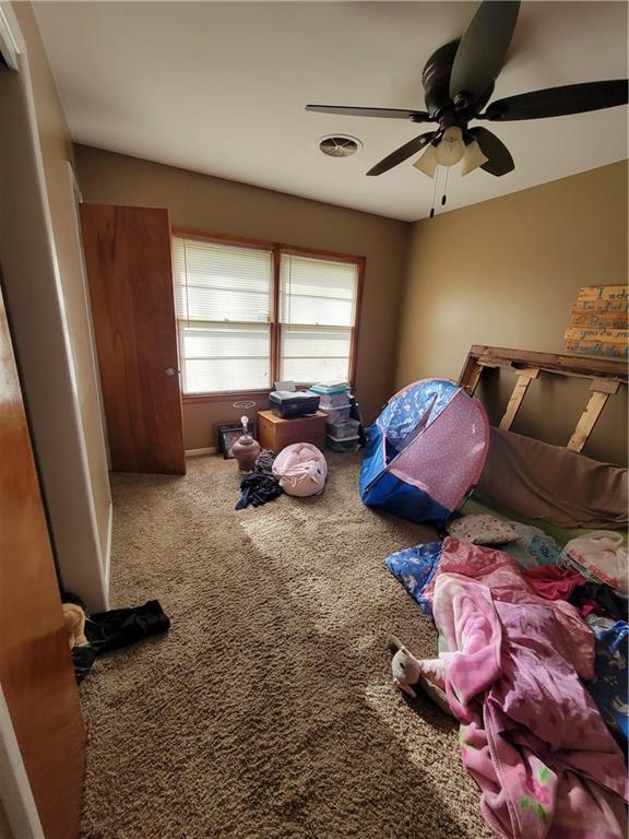 carpeted bedroom with ceiling fan and visible vents