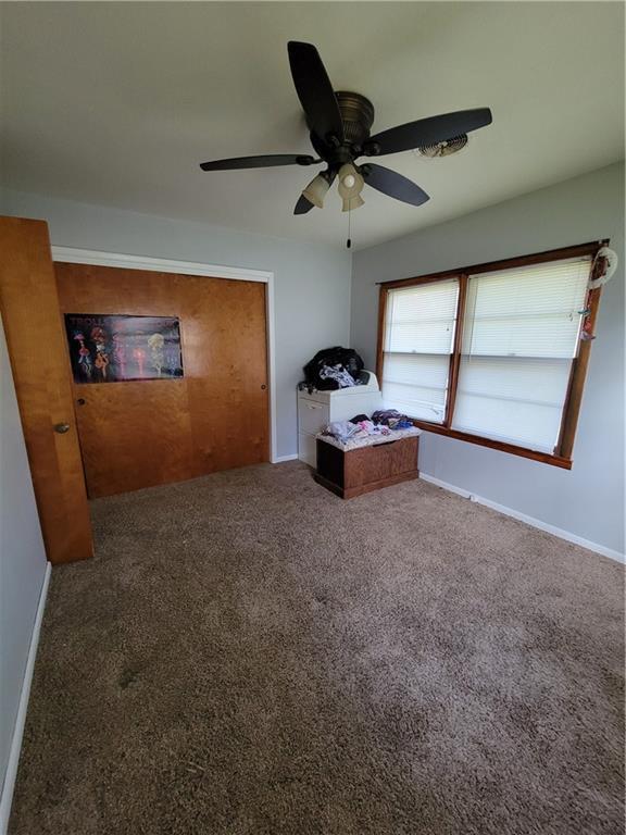 carpeted bedroom featuring a ceiling fan and baseboards