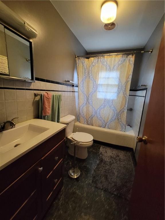 full bathroom with tile walls, vanity, toilet, and shower / tub combo