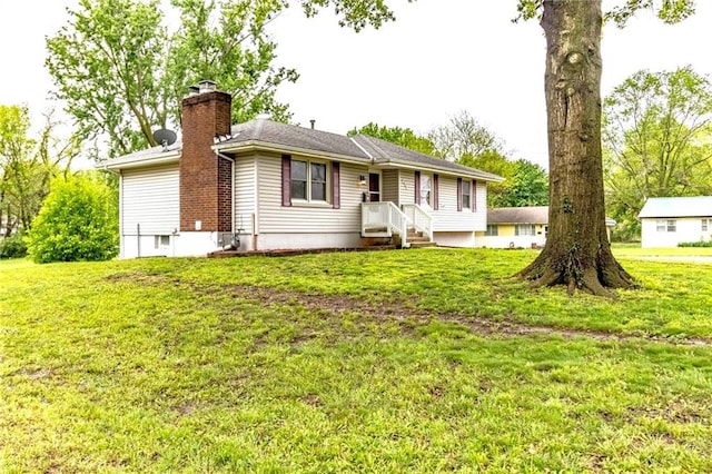 view of front of house featuring a chimney and a front yard