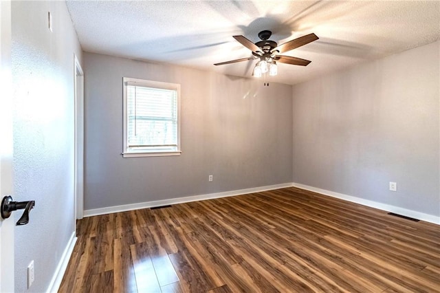 unfurnished room featuring baseboards, ceiling fan, dark wood-style flooring, and a textured ceiling