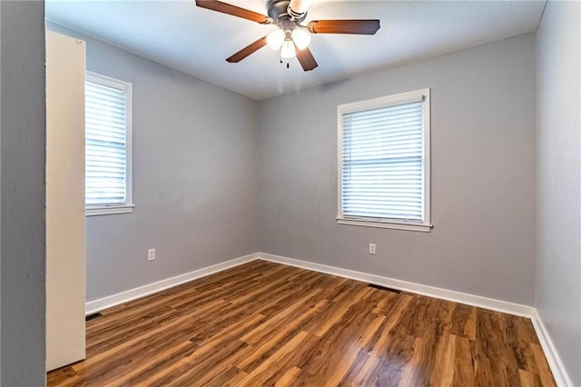 spare room featuring a ceiling fan, baseboards, and wood finished floors