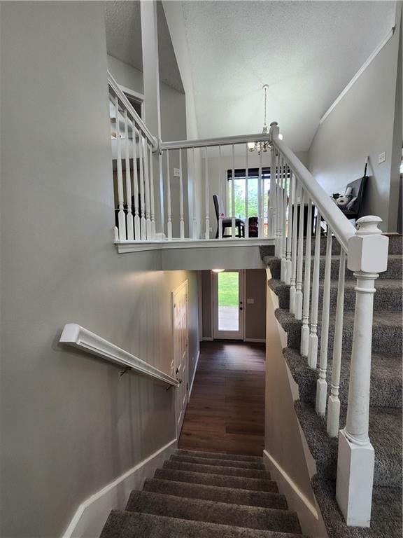 stairway with baseboards, carpet, and a notable chandelier
