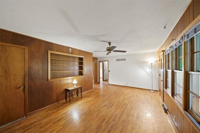 26335 W 321st Ter, Paola, KS 66071 - empty room with wooden walls, built in features, ceiling fan, and wood finished floors
