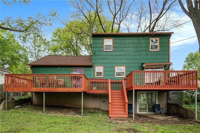 rear view of property featuring a deck, fence, a yard, a patio, and stairs