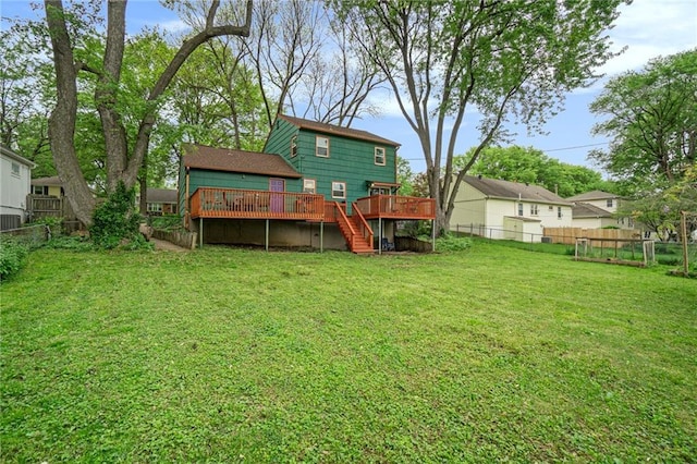rear view of property featuring stairs, a fenced backyard, a lawn, and a wooden deck