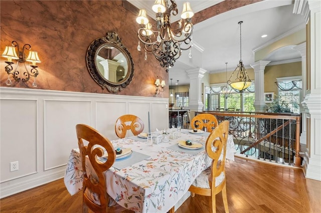 10522 N Garfield Ave, Kansas City, MO 64155 - dining area with a decorative wall, decorative columns, a chandelier, wood finished floors, and crown molding