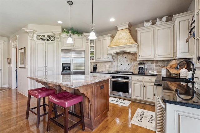 10522 N Garfield Ave, Kansas City, MO 64155 - kitchen featuring stainless steel appliances, custom exhaust hood, wood finished floors, a sink, and a kitchen island