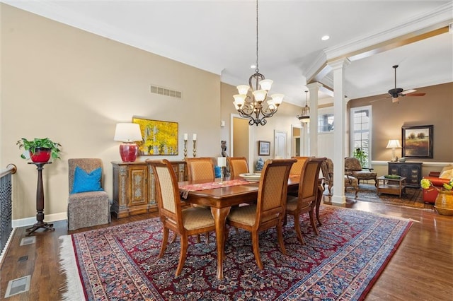 dining area featuring a chandelier, a ceiling fan, wood finished floors, crown molding, and ornate columns