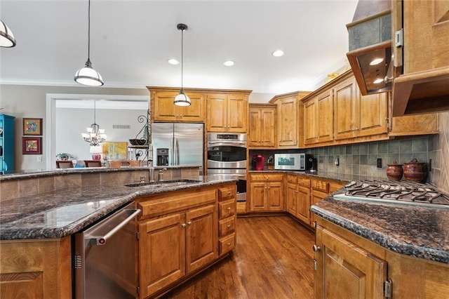 kitchen with appliances with stainless steel finishes, crown molding, brown cabinetry, dark wood-style flooring, and tasteful backsplash