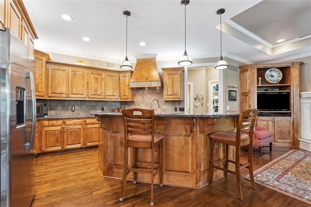 kitchen featuring stainless steel fridge, premium range hood, ornamental molding, dark wood-style flooring, and tasteful backsplash