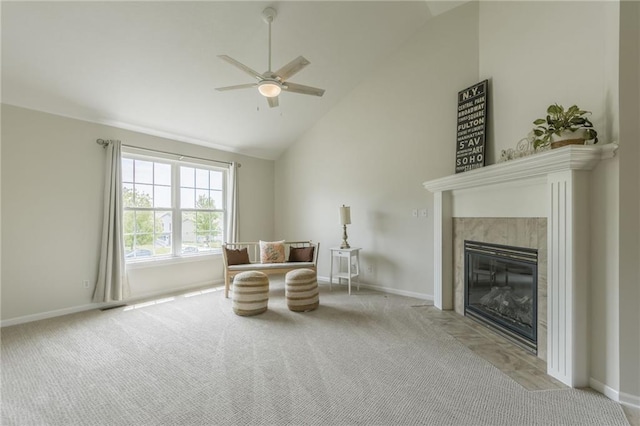 living area with a premium fireplace, ceiling fan, carpet floors, baseboards, and high vaulted ceiling
