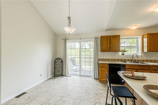 kitchen with a sink, dishwasher, brown cabinets, vaulted ceiling, and light marble finish flooring