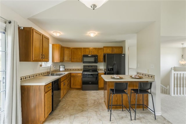kitchen with black appliances, a sink, a peninsula, and brown cabinets